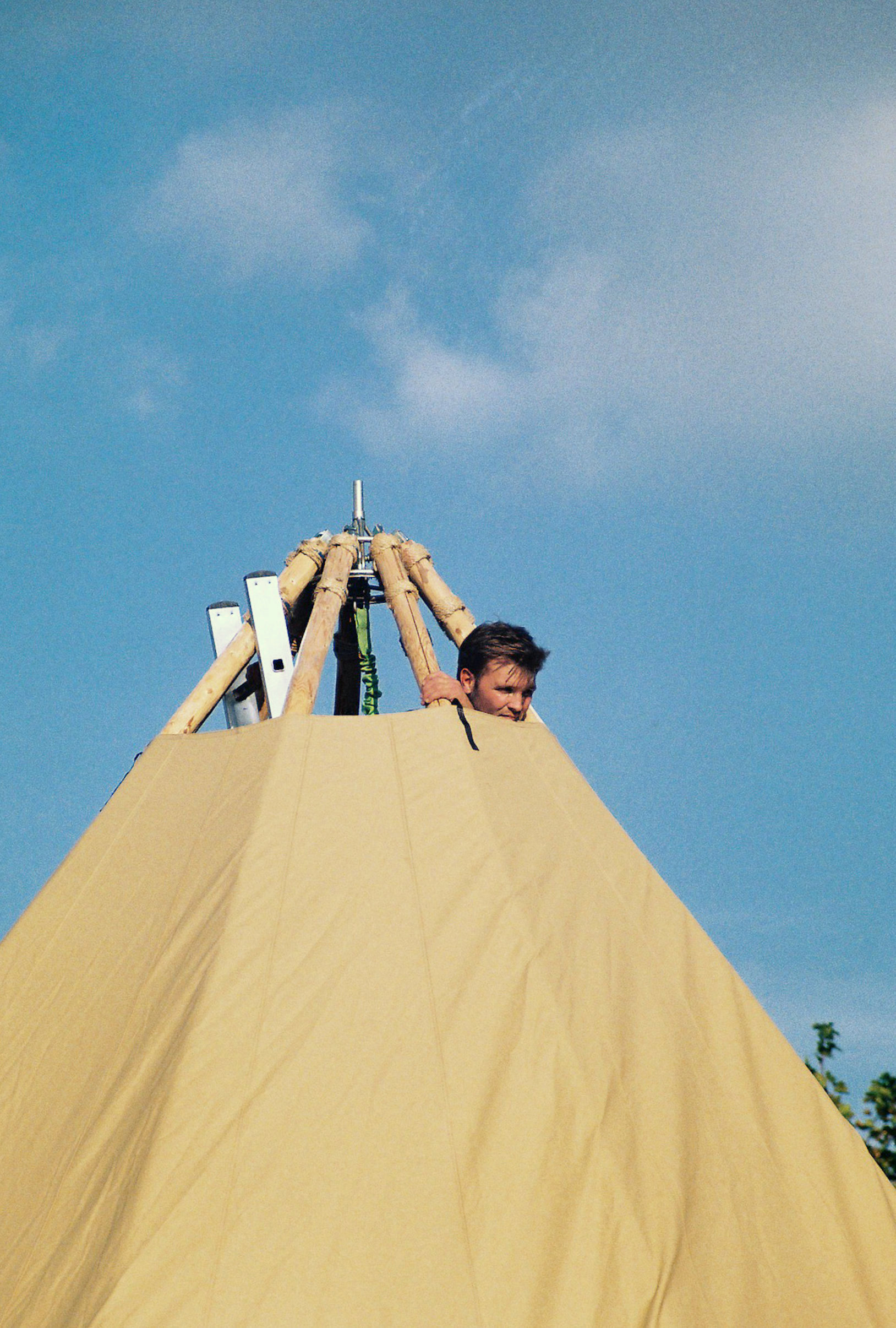 Simon looking out from top of tipi