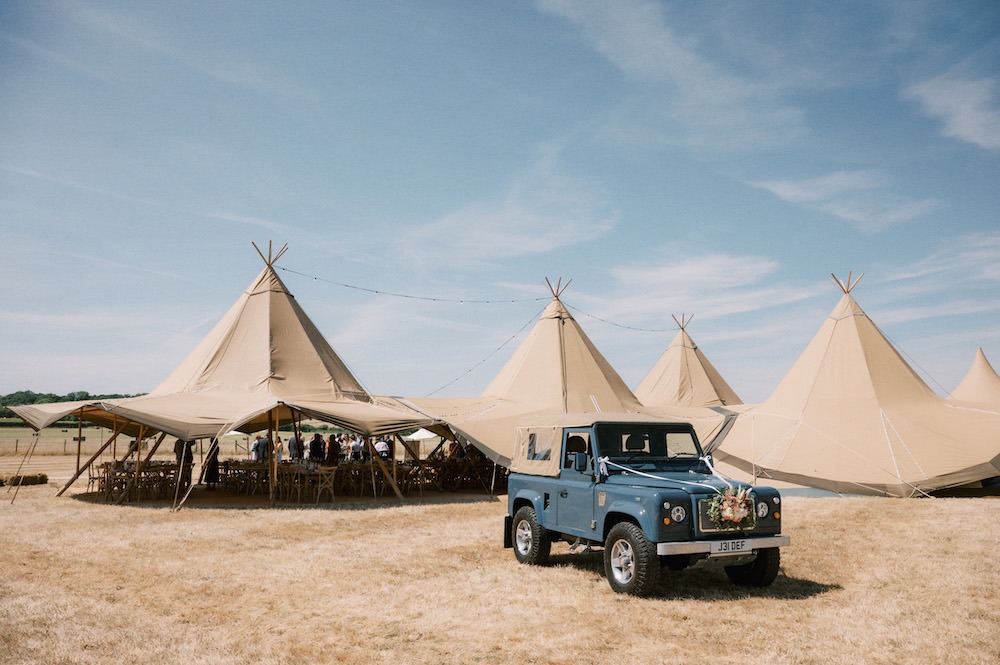 Land Rover in front of wedding tipis