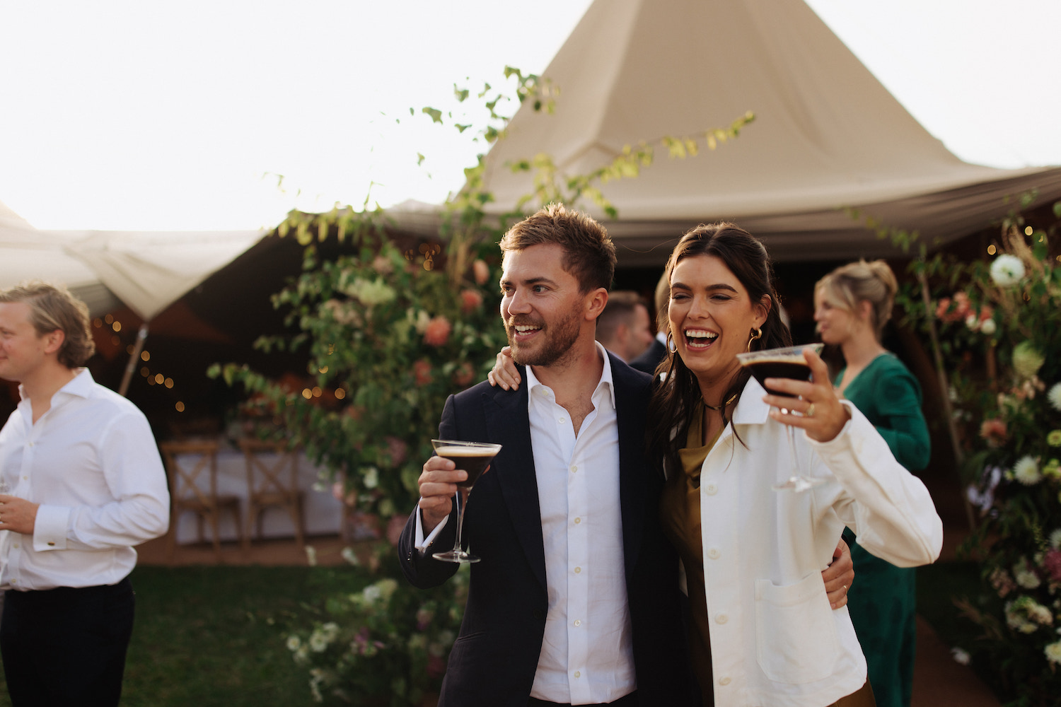 Groom and wedding guest outside wedding tipi
