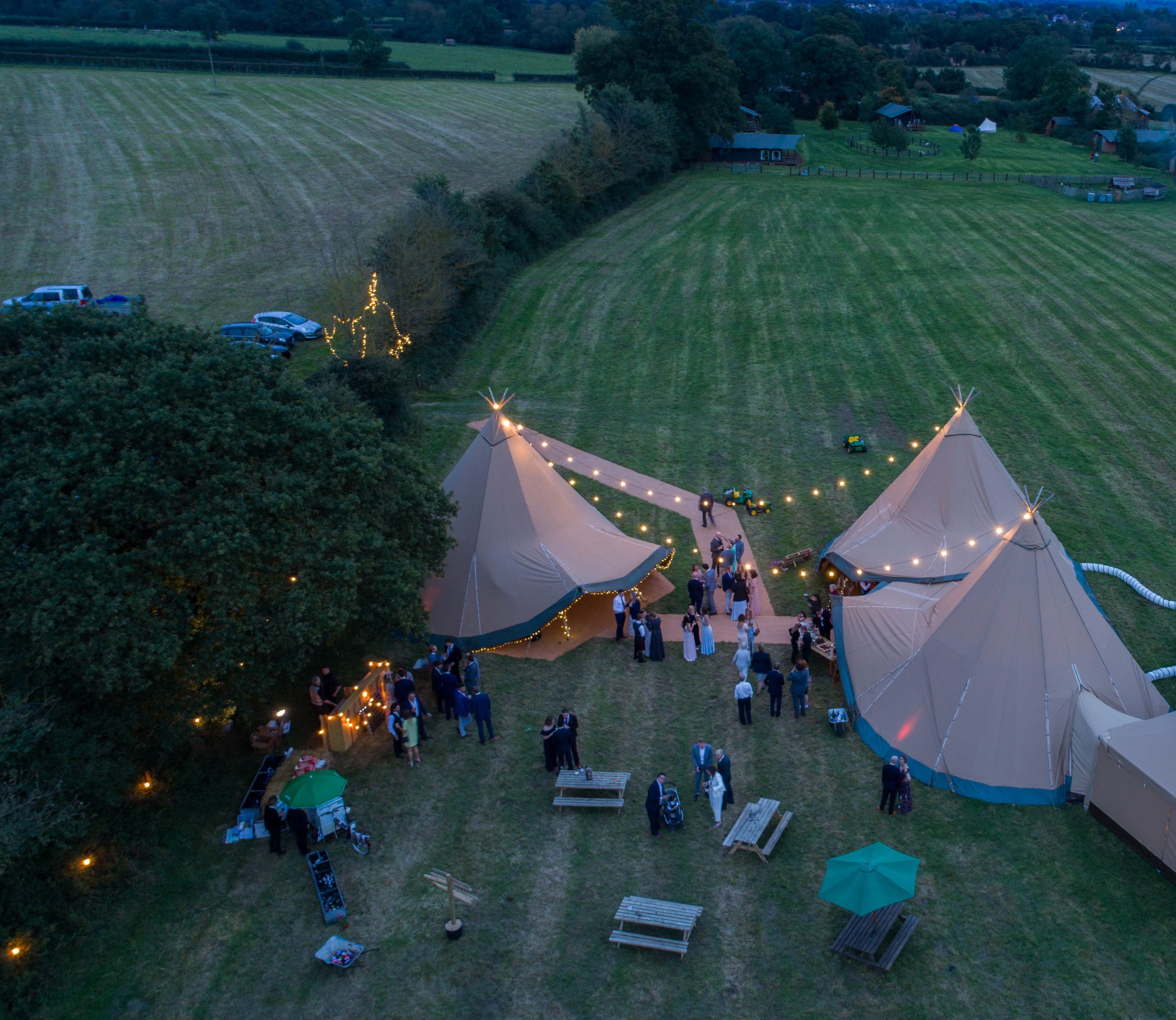 wedding tipis with festoon lighting at dusk - Buffalo Tipi and Marquee hire - West Country and Cotswolds